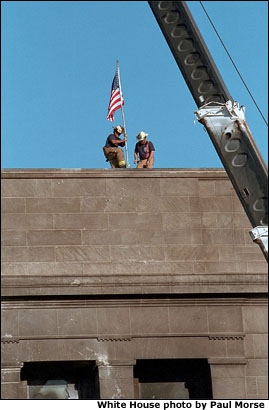One day after terrorists used commercial airplanes to destroy the World Trade Center Towers and attack the Pentagon, firefighters take a moment to post the flag into the scarred stone as inspiration for fellow rescue workers searching through the debris Sept. 12. White House photo by Paul Morse.